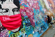 На легендарной стене Джона Леннона в Праге появились актуальные дополнения – кумира заботливо нарядили в маску, чтобы уберечь от вируса. Фото: REUTERS/David W Cerny фото 4
