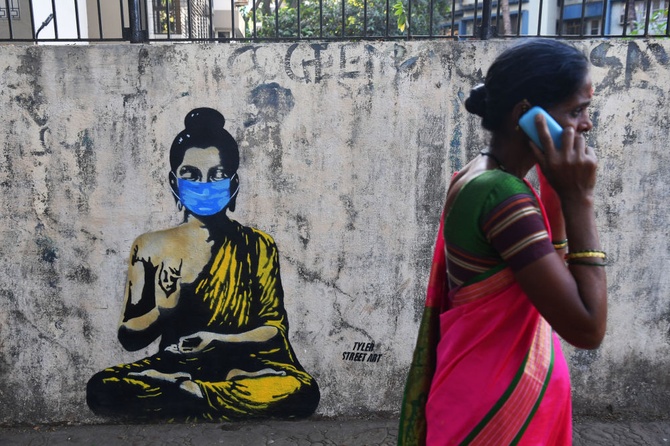 Будда в защитной маске на граффити в Мумбае призывает всех к осторожности. Фото: Indranil Mukherjee