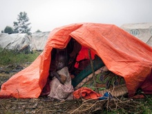 Ребенок выглядывает из палатки во время проливного дождя. Снимок сделан в день визита заместителя генерального секретаря ООН по гуманитарным вопросам Валери Амос в лагерь для беженцев в городе Гома, Демократическая Республика Конго. фото 8