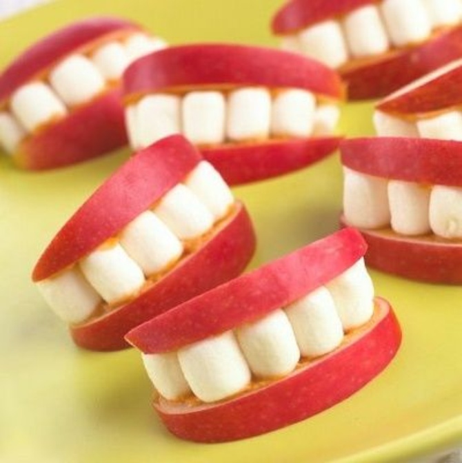 Помазать яблочные дольки арахисовым маслом или липким вареньем и влепить туда маршмеллоу - так получатся зубы