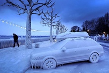 Мужчина проходит мимо покрытого льдом автомобиля. Снимок сделан у набережной в городе Версуа, недалеко от Женевы, Швейцария. фото 9