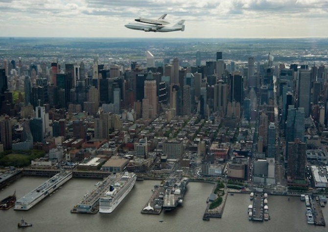 Шаттл «Энтерпрайз», установленный на вершине NASA 747 SCA, пролетает на фоне Нью-Йорка перед тем, как отправиться на плавучий музей авиации.