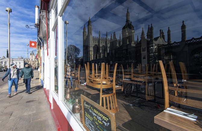 Королевский колледж в Кембридже в Великобритании отражается в окне кафе, закрытого из-за пандемии коронавируса. Кембридж, 21 марта ©Joe Giddens/PA via AP