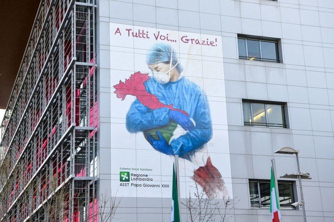 Пронзительная работа  Franco Rivolli в Бергамо, Италии, где зафиксирована самая высокая смертность от коронавируса.  На стене госпиталя изображен врач, убаюкивающий страну, завернутую в национальный флаг. Фото: Franco Rivolli Art / Piero Cruciatti