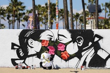 Художница Пони Вейв, напротив, напоминает жителям калифорнийской Венеции, что любовь любовью, а маски все же снимать не стоит, так как США  - лидер по количеству жертв пандемии. Фото: Getty Images/Mario Tama фото 6